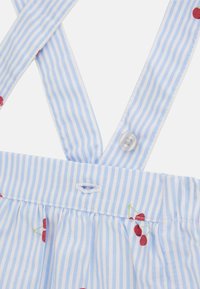 Abito in tessuto a righe blu e bianche con ricami di ciliegie rosse, spalline regolabili e chiusura con bottone sul retro. Vita arricciata.