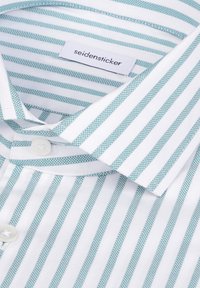 Chemise blanche à rayures turquoise clair, col pointu et fermeture par boutons. Étiquette indiquant "seidensticker." Texture lisse.