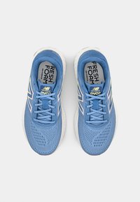 Scarpe da ginnastica blu con superiore in tessuto a rete, dotate di accenti chiari, suola imbottita e lacci. Logo visibile sulla linguetta.