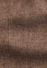 Tissu marron texturé avec un motif de tissage diagonal subtil et une couture verticale visible sur le côté gauche.