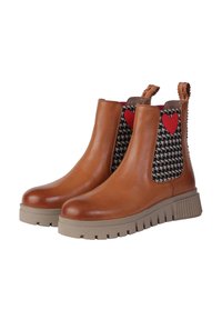 Brązowe skórzane botki za kostkę z czarnym wzorem houndstooth, czerwoną serduszkiem po boku oraz beżową masywną podeszwą o rowkowanej fakturze.