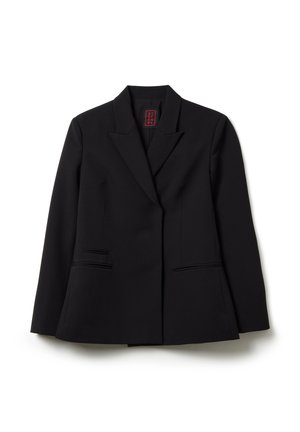 Veste blazer noire sur mesure avec revers en pointe, manches longues et deux poches poitrine posées à plat sur un fond blanc.
