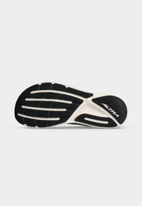 Semelle de chaussure avec un motif de bande de roulement noir et blanc et le nom de la marque Altra sur fond blanc.