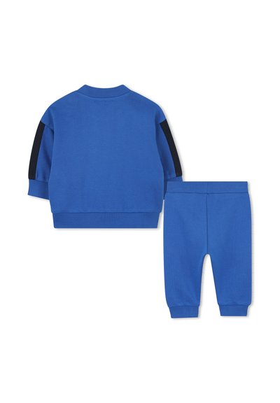 Blauwe sweatshirt met zwarte accenten op de mouwen, met een ronde hals en geribde manchetten. Gecombineerd met bijpassende blauwe joggerbroeken.