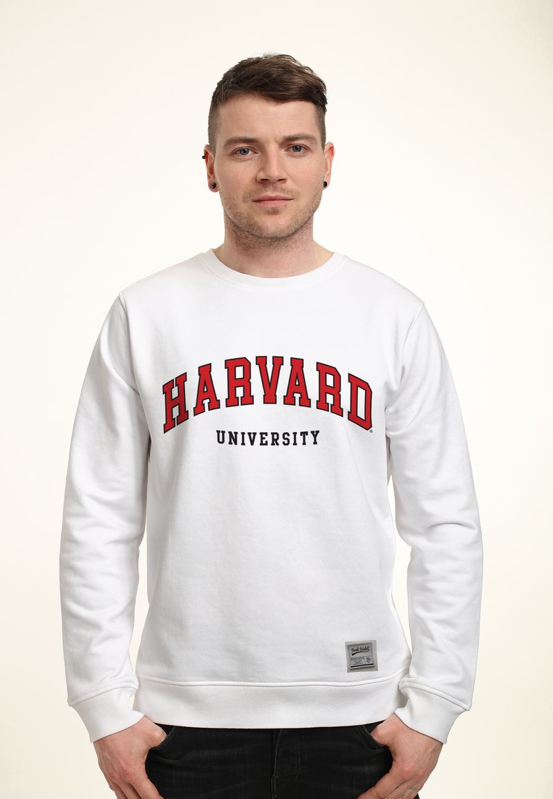 Bílá mikina s potiskem "HARVARD" a "UNIVERSITY" v červené a černé barvě. Obsahuje žebrované manžety a štítek na dolním lemu. Hladký povrch.