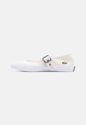White canvas Mary Jane shoe with a buckle strap, rubber sole, and green crocodile logo on the side.