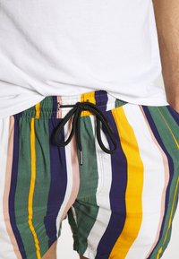 Raidalliset uimalahkeet, joissa on nyöri vyötäröllä. Ominaisuuksia kirkkaissa väreissä: keltainen, vihreä, sininen ja vaaleanpunainen, ja kevyet kangasrakenteet.