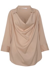 Beige pitkähihaine pusero, jossa on valuva muotoilu ja V-mallinen kaula-aukko. Valmistettu sileästä kankaasta, siinä on rento leikkaus ja pyöristetty helma.