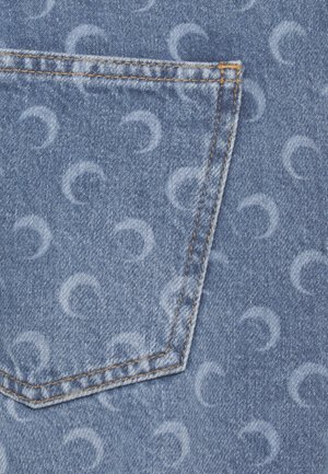 Tessuto di denim blu con una tasca posteriore, con motivi chiari a mezzaluna e cuciture arancioni lungo i bordi della tasca.