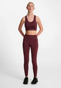 Bordeaux sports-bh og leggings sæt i et elastisk, glat stof. Leggings har en bred, høj talje og logo-detaljer.