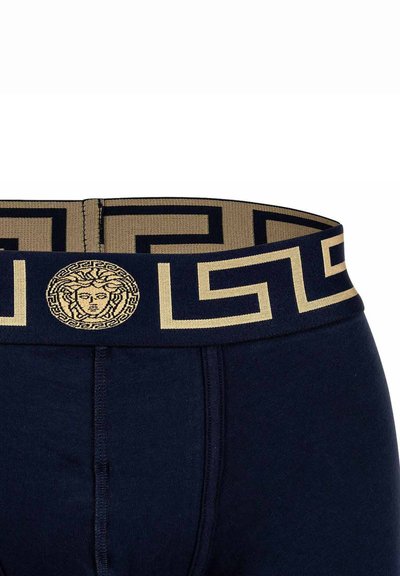 Navy blue boxer briefs with a patterned gold waistband featuring a Greek key design and a central Medusa logo in the front.