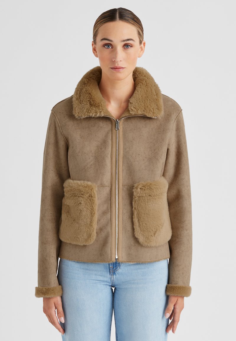 Braune Kunstfelljacke mit Reißverschluss, großen frontalen Taschen und einem weichen, zotteligen Kragen. Verfügt über eine kuschelige Textur und eine taillierte Passform.