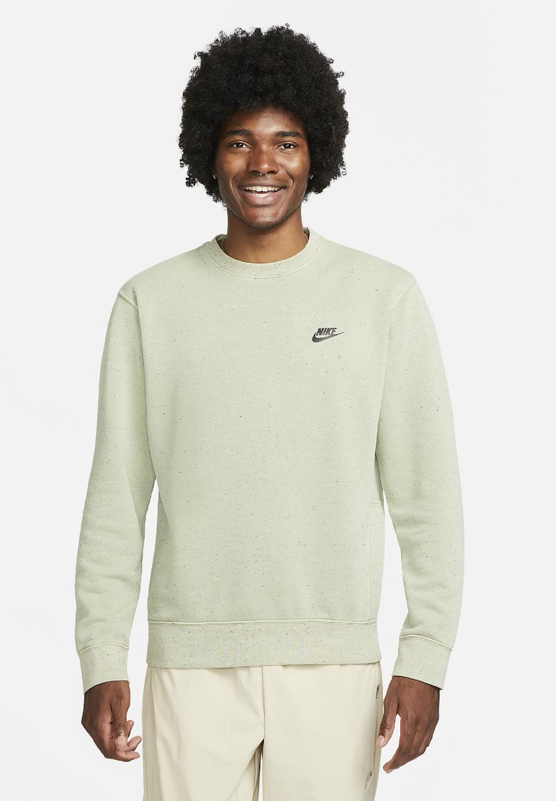 Ljusgrön sweatshirt i bomullsblandning, med rundad hals, långa ärmar och en liten svart Nike-logga på bröstet. Strukturerade prickar finns.