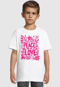 Hvit bomullst-skjorte med korte ermer, med et rosa blomsterdesign og teksten "PEACE LOVE" i fete bokstaver.