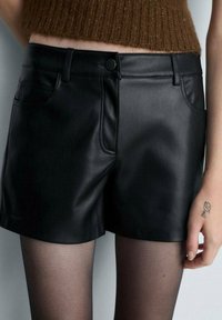 Černé šortky z umělé kůže s hladkým povrchem, mají přiléhavý pas, přední kapsy a klasický design.