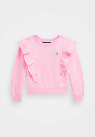 Rosa sweatshirt med volangdetaljer på axlarna. Tillverkad av mjukt material, med rund halsringning och liten blå logotyp på bröstet.