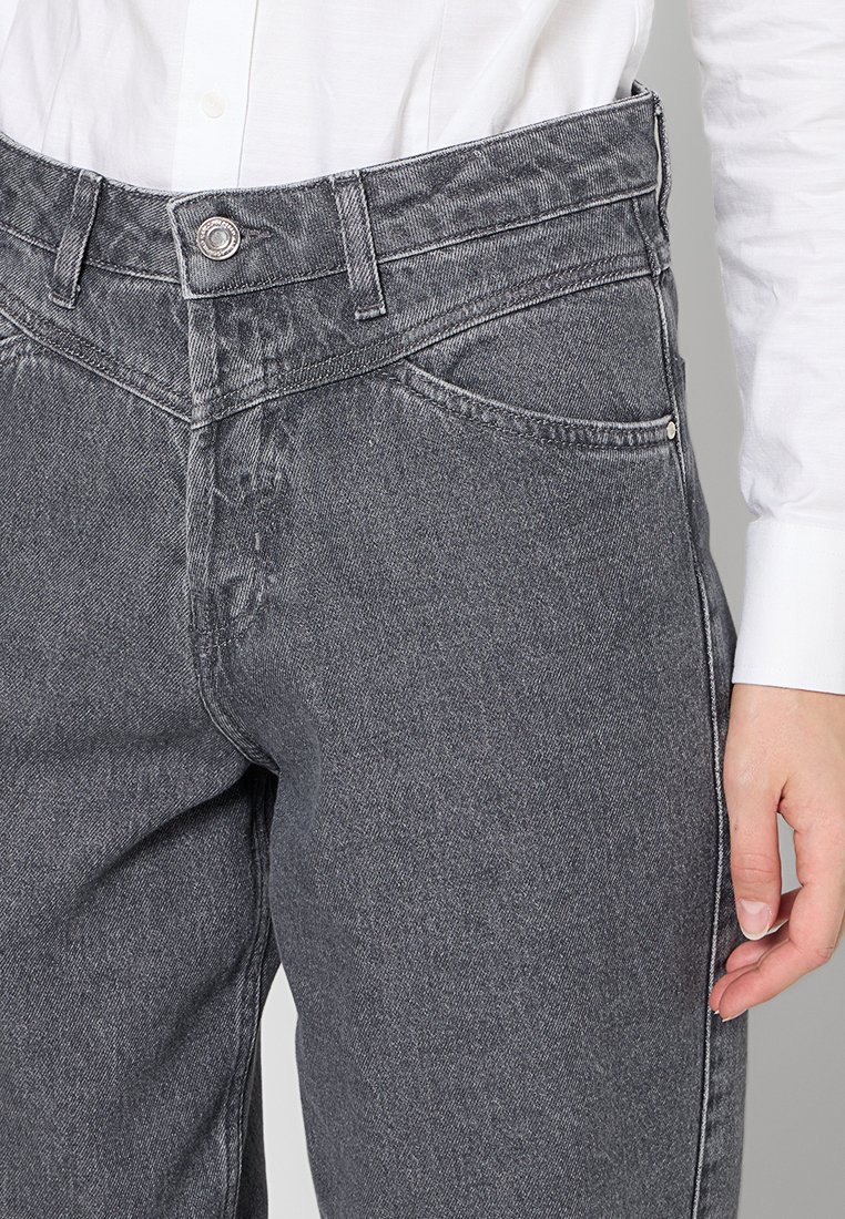 Pantaloni in denim grigio a vita alta, con un bottone metallico, tasche anteriori e una sottile texture sbiadita. Il tessuto ha una finitura morbida.