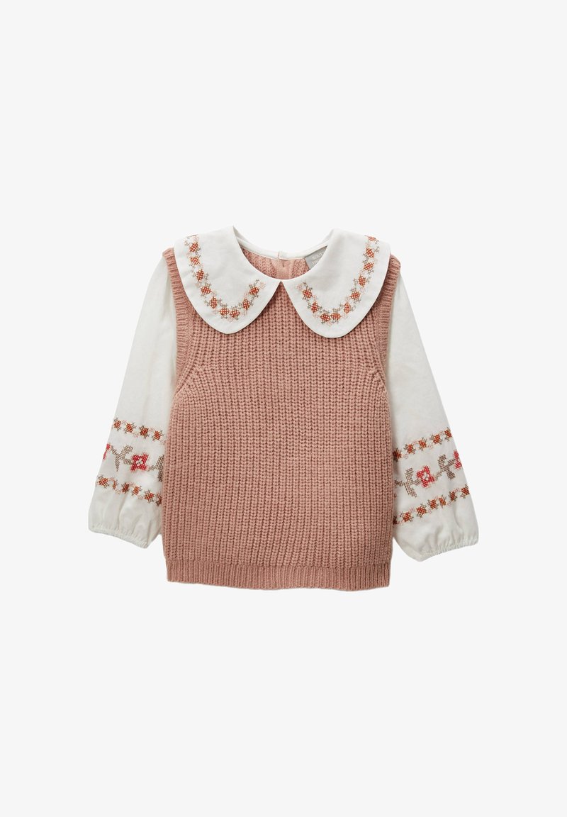 Haut sans manches en tricot rose avec une chemise blanche en dessous. Le col est orné de broderies florales ; les manches sont bouffantes avec des accents décoratifs.