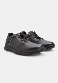 Pantofi din piele neagră cu un design de tip low-top, vârf rotund, sistem de închidere cu șireturi și talpă din cauciuc texturat pentru aderență. Accentați cu cusături subtile.