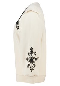 Witte trui met zwarte geborduurde bloemen, met een losse pasvorm, geribde boorden en een gestructureerde stof. Gedetailleerd bloemenpatroon op het schoudergebied.