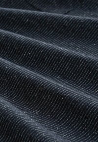 Tejido oscuro con una textura suave, que presenta sutiles rayas onduladas en diferentes tonos de azul y gris, dispuestas en un patrón en ondas.