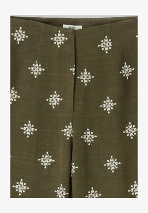 Tissu vert olive avec un motif brodé géométrique blanc en forme d'étoile, présentant une couture centrale et une petite étiquette visible en haut.