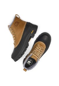 Bottes imperméables en cuir marron et caoutchouc noir avec col en polaire grise. Elles comportent des lacets ronds, une semelle robuste et une marque visible.