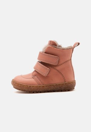 Bottine enfant rose avec deux brides velcro, semelle marron texturée et doublure intérieure en fourrure beige douce visible en haut.