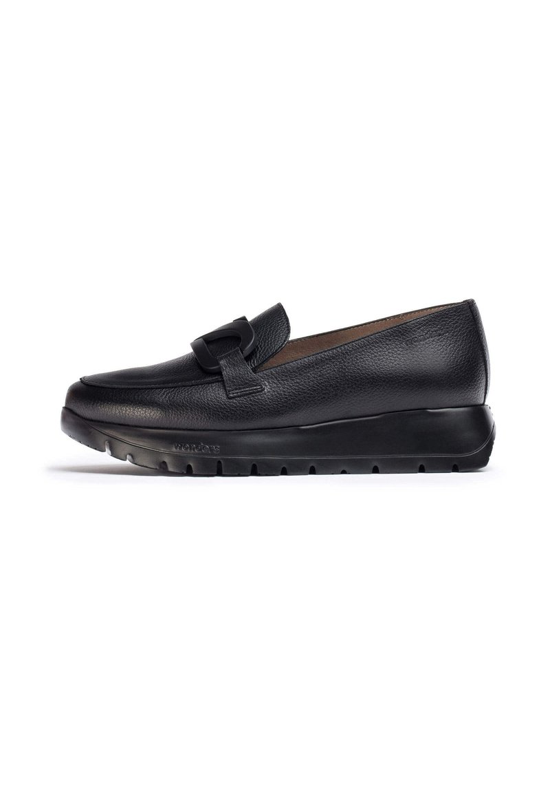 Scarpa nera in pelle scamosciata senza lacci con punta arrotondata, caratterizzata da una fascia decorativa e una spessa suola in gomma nera con scanalature per una migliore aderenza.