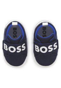 Mornarske plave platnene cipele s bijelim logotipom "BOSS", koje imaju čičak traku, okrugli vrh i udoban interijer s plavim naglasima.