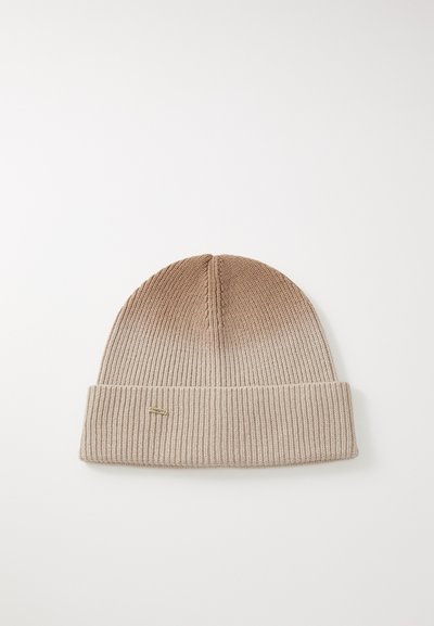 Kootud beanie gradiente beežides toonides, painutatud äär ja väike kuldne silt. Omab soonikteksti ja ümarat krooni.