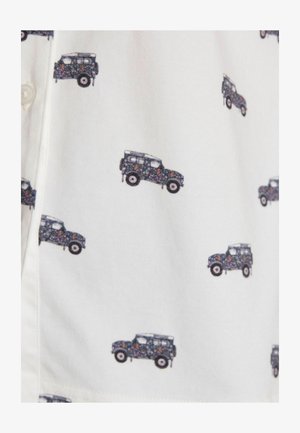Majica kratkih rukavov iz belega blaga, ki je prekrita z motivom majhnih temno modrih vozil z cvetličnimi vzorci, tiskana enakomerno po površini.