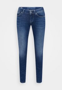 Jeans skinny de mezclilla azul oscuro con una cintura de media altura, que presentan un diseño de cinco bolsillos y un ligero desgastado a lo largo de las piernas.