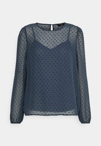 Blusa transparente azul-marinho com mangas longas e textura de bolinhas, apresentando uma gola em V e detalhe em forma de chave nas costas. Design leve e fluido.