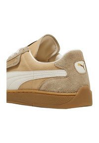 Beige Wildlederschuhe mit einem weißen Lederstreifen, strukturiertem Gummisohle und gepolstertem Kragen; verfügt über ein kleines Logo an der Ferse.
