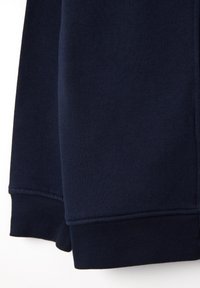 Marineblaues Sweatshirtmaterial mit gerippten Bündchen. Glatte Textur, doppelte Naht an den Nähten und ein zeitgemäßes, lässiges Design.