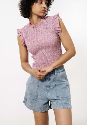 Top en tricot rayé rouge et blanc avec des manches courtes volantes ; associé à un short en denim bleu clair taille haute avec des poches avant.