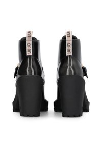 Schwarze Lackleder-Ankle Boots mit dicken schwarzen Platform-Absätzen, einer Zuglasche hinten und einer Schnallenverzierung an der Seite. Glatte Textur.