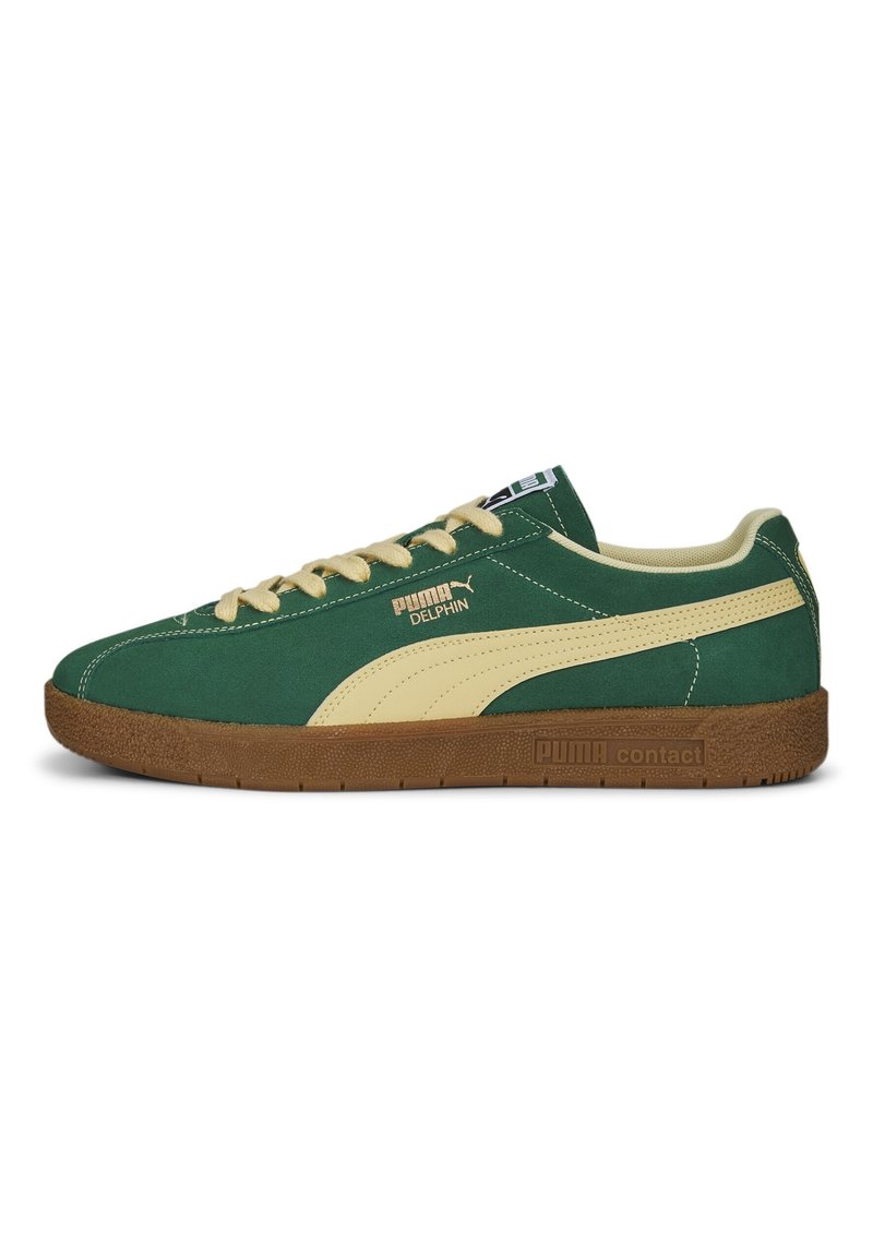 Zapatillas de ante verde con acentos crema, suela de goma y marca en dorado. Presentan punta redondeada, cordones planos y un patrón de relieve en la suela.