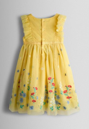 Den gule tylkjole har flæseærmer, knapper bagpå og broderede blomsterdesigns i rødt, blåt og hvidt.