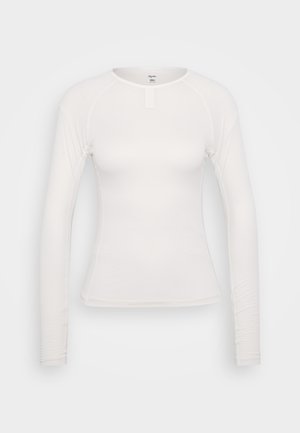 Biela košeľa s dlhým rukávom, s priliehavým strihom, textúrovanou tkaninou, okrúhlym výstrihom a malým zapínaním vpredu. Hladký povrch a žiadne viditeľné vzory.