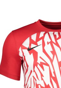 Rood sportshirt met korte mouwen, voorzien van een wit zigzagpatroon, ronde halslijn en een zwart Nike-logo op de borst. Gemaakt van ademende stof.