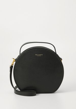 Pyöreä musta käsilaukku, joka on valmistettu teksturoidusta synteettisestä materiaalista. Laukussa on yläkahva, säädettävä hihna ja kultaiset logokoristeet.