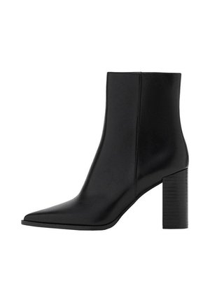 Botte chelsea en cuir noir avec un bout pointu, un talon carré, une texture lisse et des détails de couture le long des coutures. Les talons mesurent environ 8,9 cm.