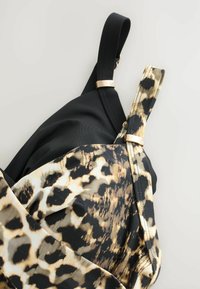Černý bikinový top s leopardím vzorem, s nastavitelnými ramínky a zlatými kovovými detaily, obsahující mix textur a barev.