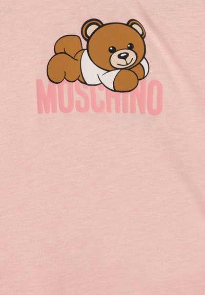 T-shirt di cotone rosa con un orsetto cartone animato che indossa una maglietta bianca e il nome del marchio "MOSCHINO" in grassetto rosa sotto il disegno.