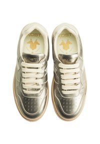 Baskets métalliques dorées avec une tige en cuir lisse, un bout perforé et des lacets crème ; présentent des accents dorés sur la semelle intérieure et le logo.