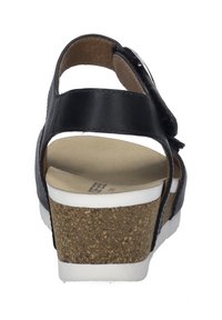 Schwarze Leder-Wedgesandale mit Kork- und weißer Gummisohle, verstellbarem Riemen und abgerundetem Absatz. Hat eine glatte Textur und minimale Designdetails.