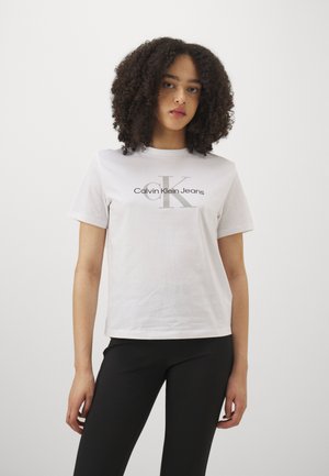 T-shirt in cotone bianco con maniche corte e scollo rotondo, con logo grigio "Calvin Klein Jeans" e grafica "CK" sul davanti.