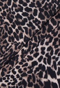 Tessuto in stampa leopardata con un motivo animale in tonalità di beige e nero, morbido al tatto e con una finitura liscia.